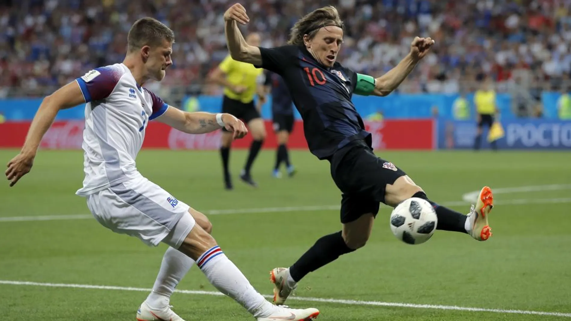 Luka Modric trata de interceptar un centro del islandés Johann Gudmundsson / Ap