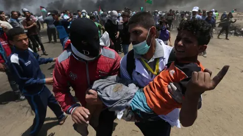 Un niño es evacuado durante las protestas por el traslado de la Embajada de EE UU a Jerusalén en la Franja de Gaza / Reuters