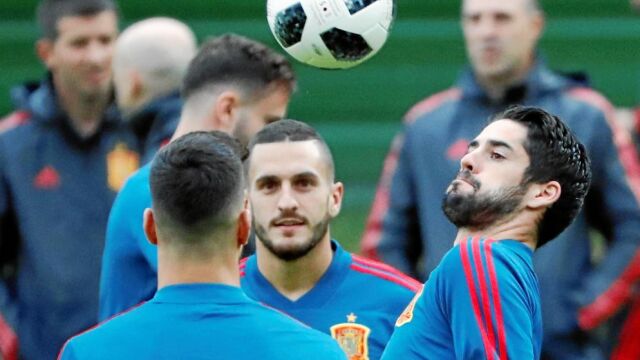 Isco cabecea el balón junto a Koke, en el entrenamiento de ayer