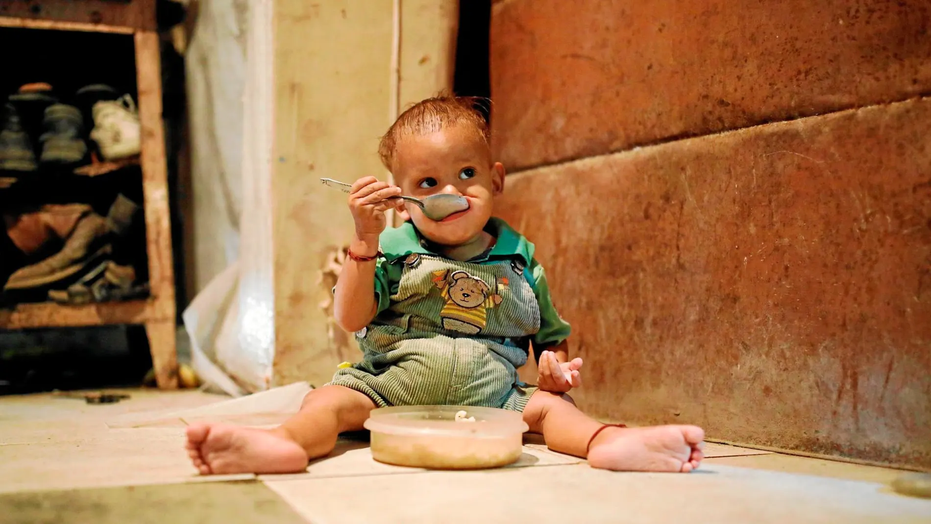 Yeibe Medina, una niña de apenas un año, se alimenta a sí misma en su casa cerca de San Francisco de Yare / Reuters