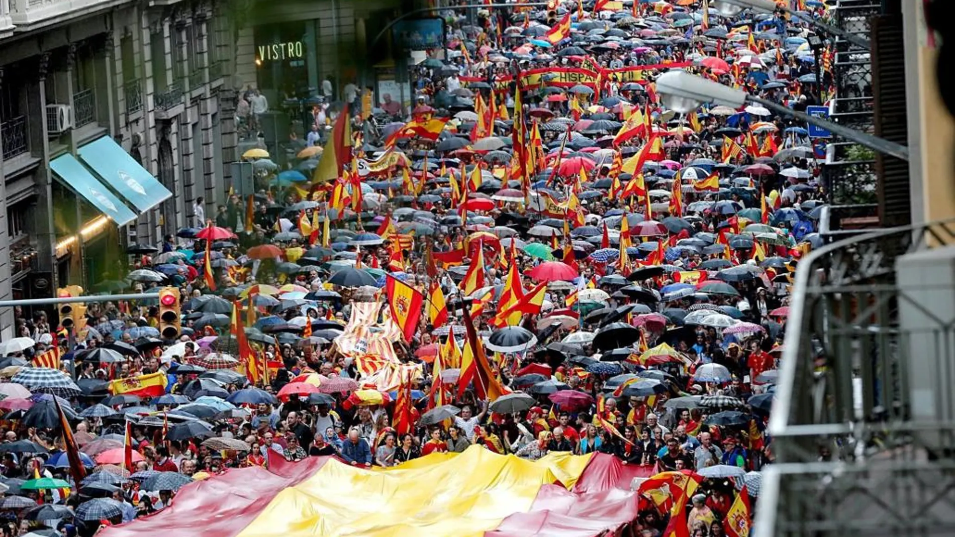 Varios participantes portan la bandera española durante la manifestación convocada por Movimiento Cívico de España y Catalanes, hoy por la Vía Layetana, en Barcelona, con el lema "Catalunya es Espanya. Democracia, futuro y libertad".