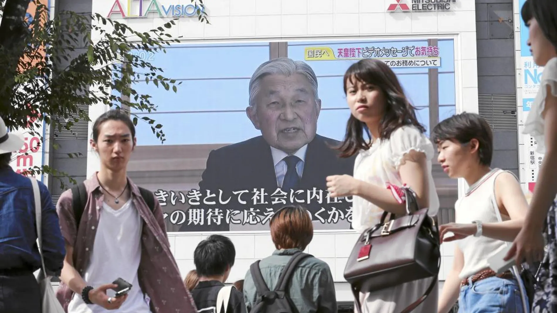 Ciudadanos nipones escuchan, desde las calles de Tokio, el discurso televisado de diez minutos del emperador Akihito