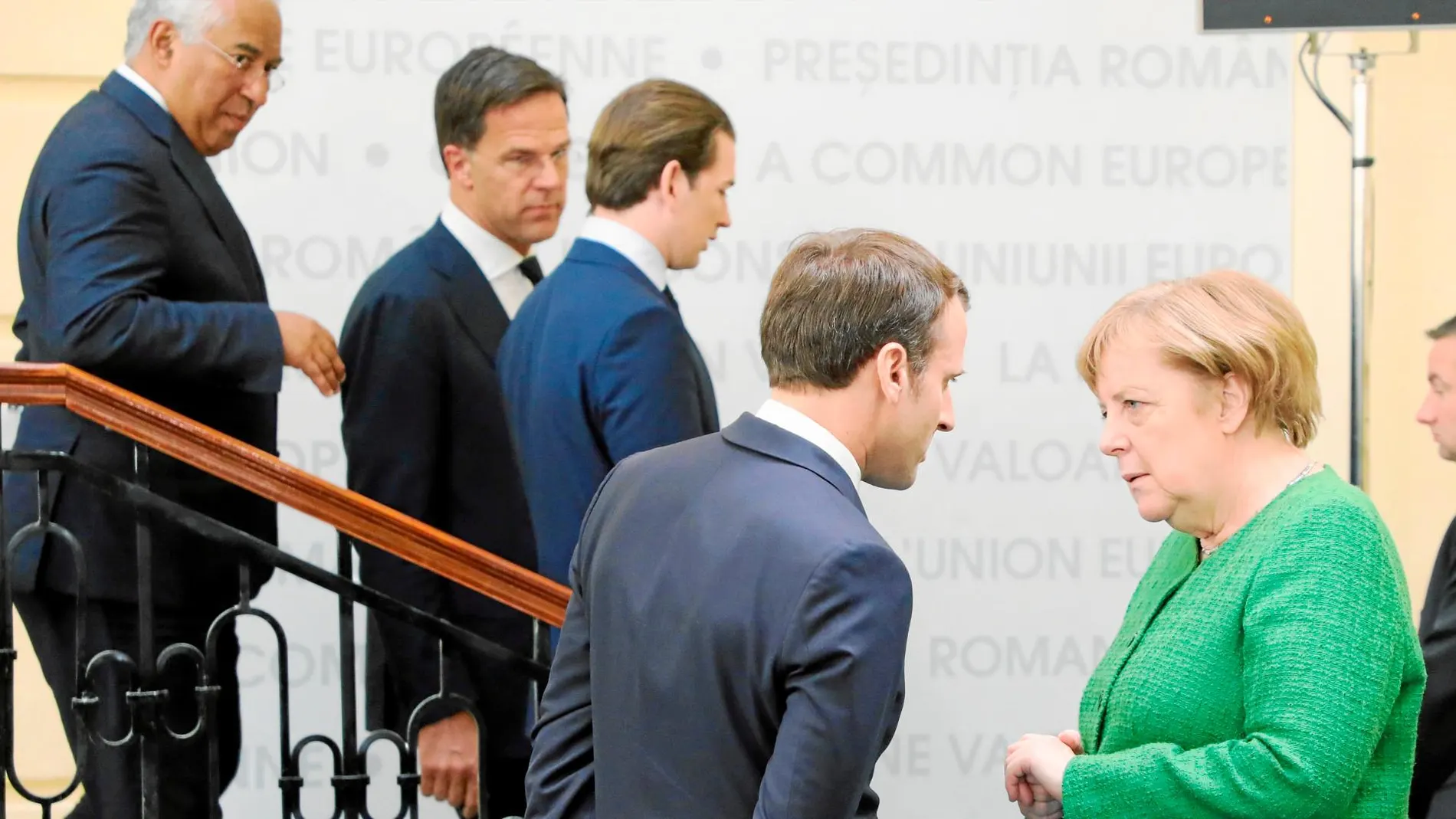 El presidente francés, Emmanuel Macron, y la canciller Angela Merkel conversan ante otros líderes europeos en la cumbre de Sibiu, en Rumanía