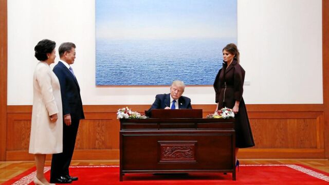 El presidente surcoreano, Moon Jae In, y su mujer esperan mientras Trum y Melania participan en la ceremonia de firmas en el libro de invitados ilustres de la Casa Azul