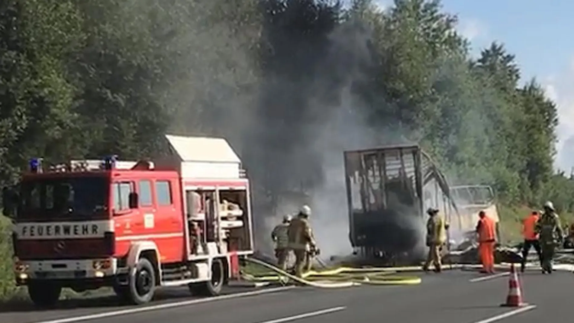 Bomberos junto al autobús calcinado