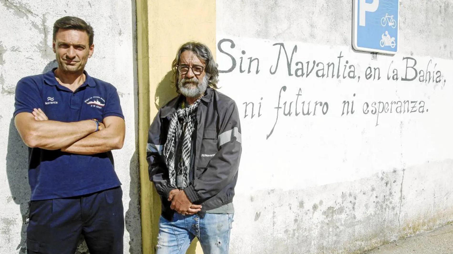 José Manuel Pinto Barroso, del comité de empresa de Navantia, y  Enrique Martínez, con 42 años de antigüedad, posan en la entrada del astillero gaditano. Foto: Manuel Olmedo