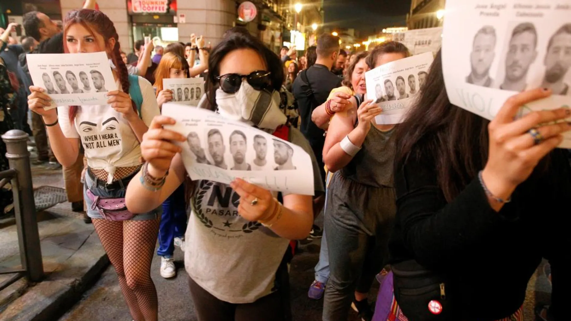 Unas manifestantes portan fotografías de los integrantes de La Manada. Efe