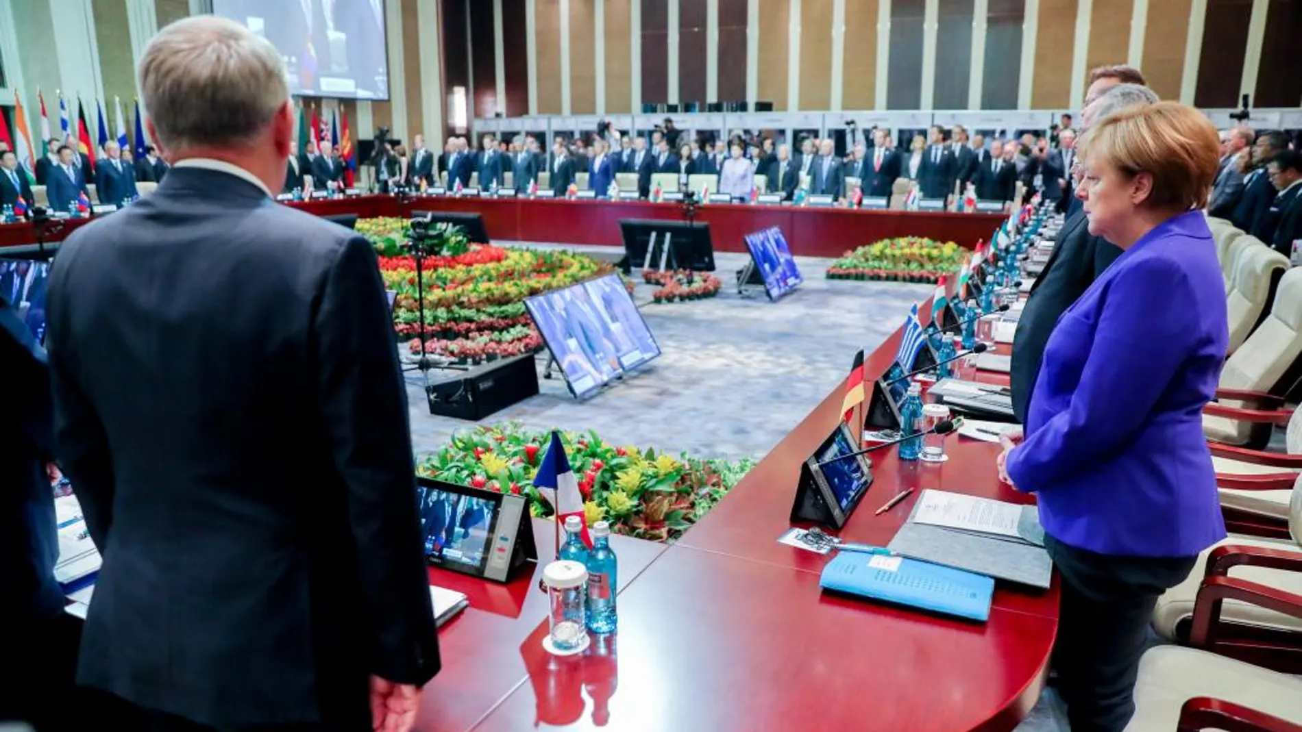 La canciller alemana Ángela Merkel, quien asiste junto al ministro de Relaciones Exteriores francés, Jean-Marc Ayrault, a una reunión de la Cumbre (ASEM) Asia-Europa en Ulan Bator (Mongolia) guardan un minuto de silencio por las víctimas de Niza