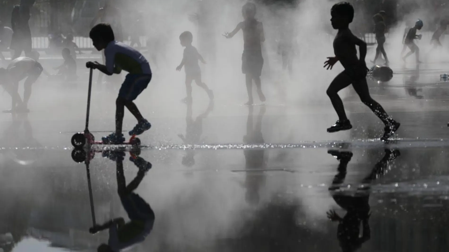 Un grupo de niños jugando con agua en la última ola de calor en Francia