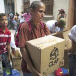 Comida por votos. Una mujer lleva una caja, muy popular en Venezuela llamada Clap, con alimentos básicos como arroz y leche en polvo suministrada por el Gobierno