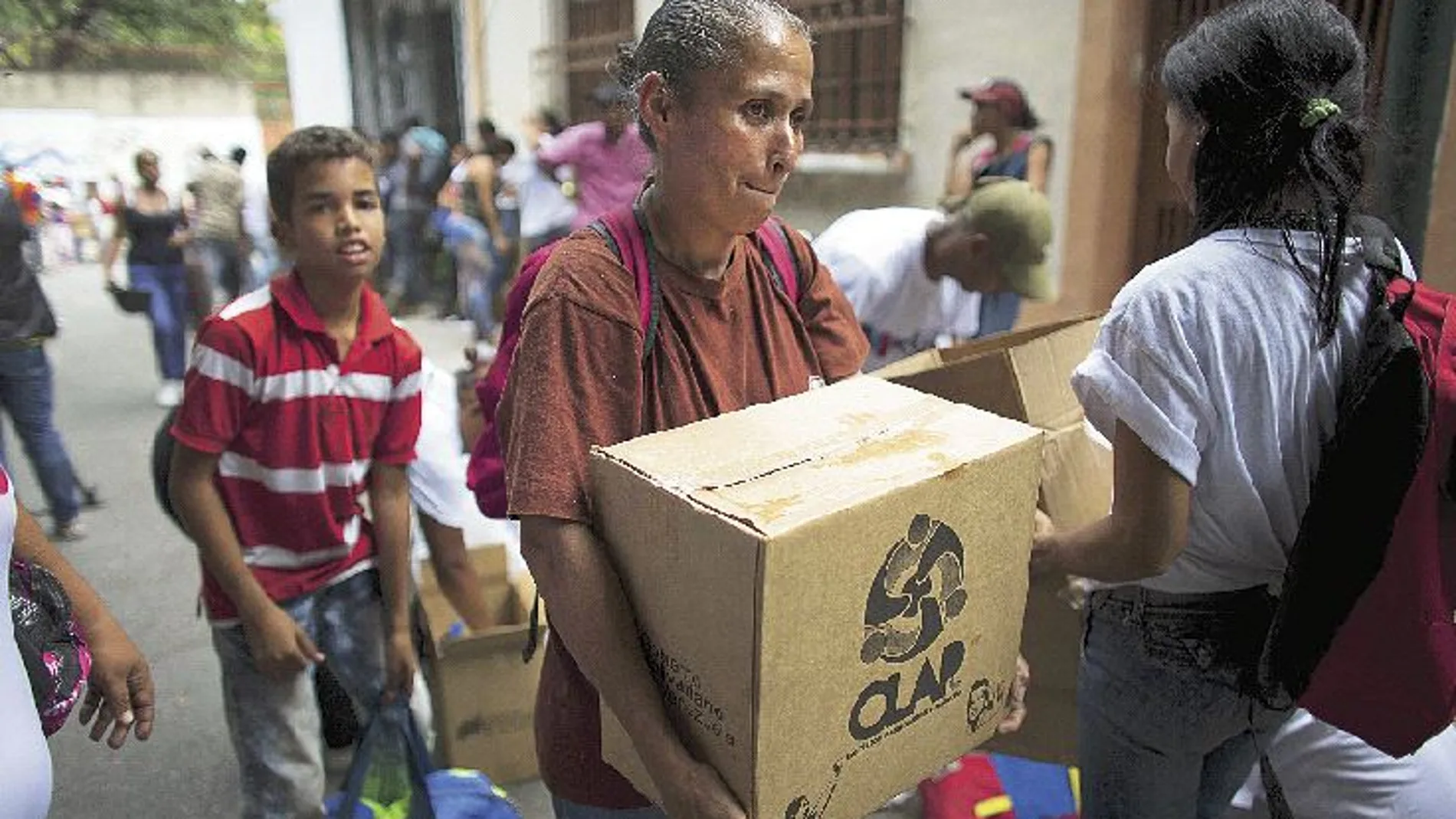 Comida por votos. Una mujer lleva una caja, muy popular en Venezuela llamada Clap, con alimentos básicos como arroz y leche en polvo suministrada por el Gobierno