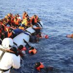 Varios inmigrantes, que han caído al agua, son rescatados por sus compañeros y por miembros de Cruz Roja cerca de Malta