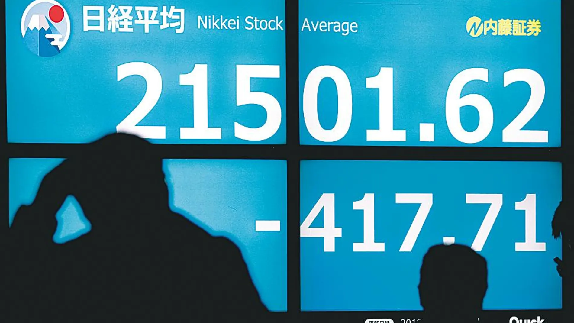 Varias personas observan la caída sufrida ayer por el índice Nikkei de la bolsa de Tokio (Japón)