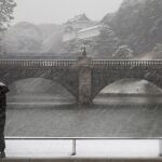 Una mujer se protege con paraguas mientras pasea delante del Palacio Imperial durante una fuerte nevada en Tokio, Japón, hoy