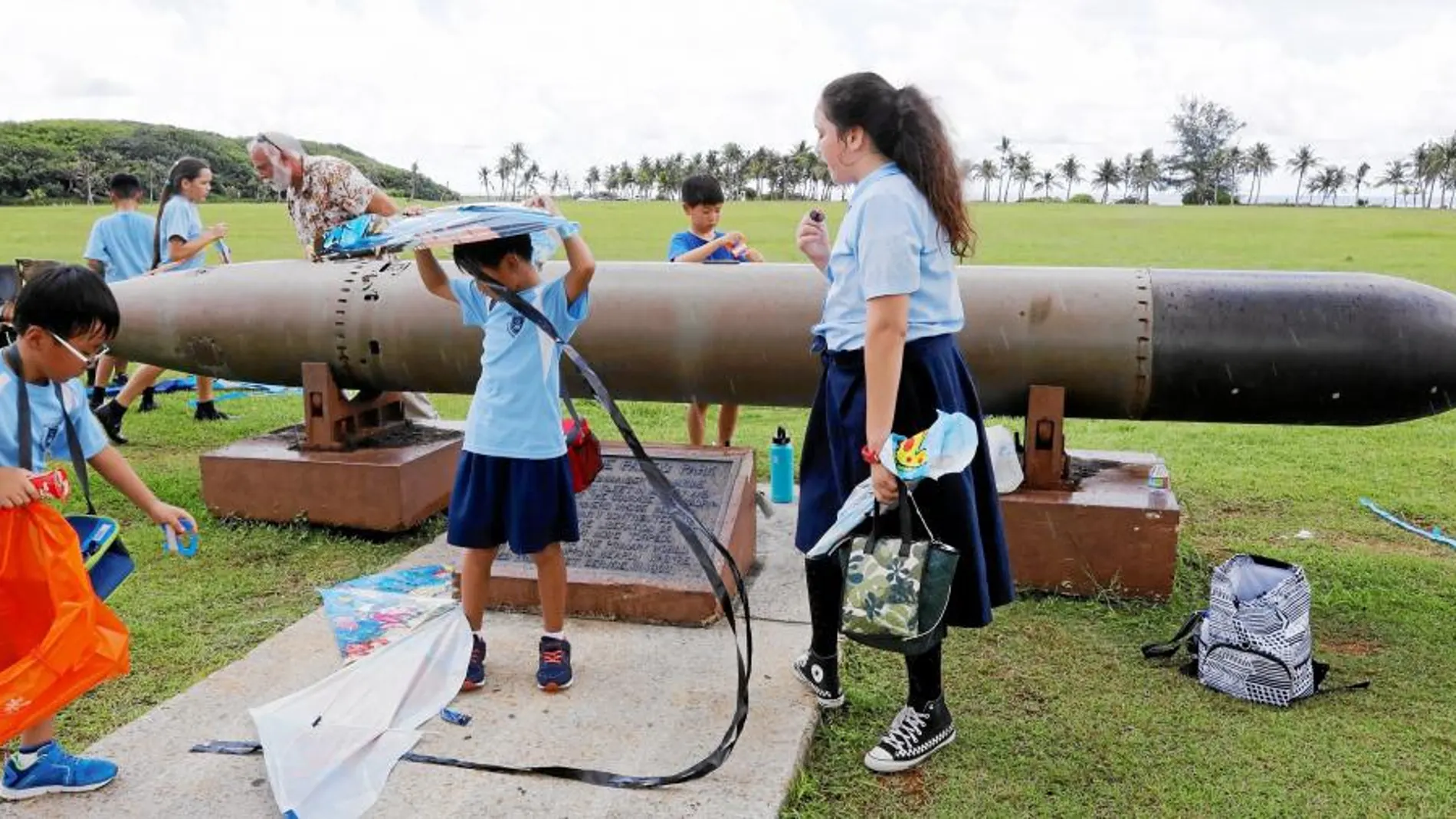 Un grupo de escolares juega cerca de un torpedo de la II Guerra Mundial en el Asan Memorial Park, en Guam, el viernes