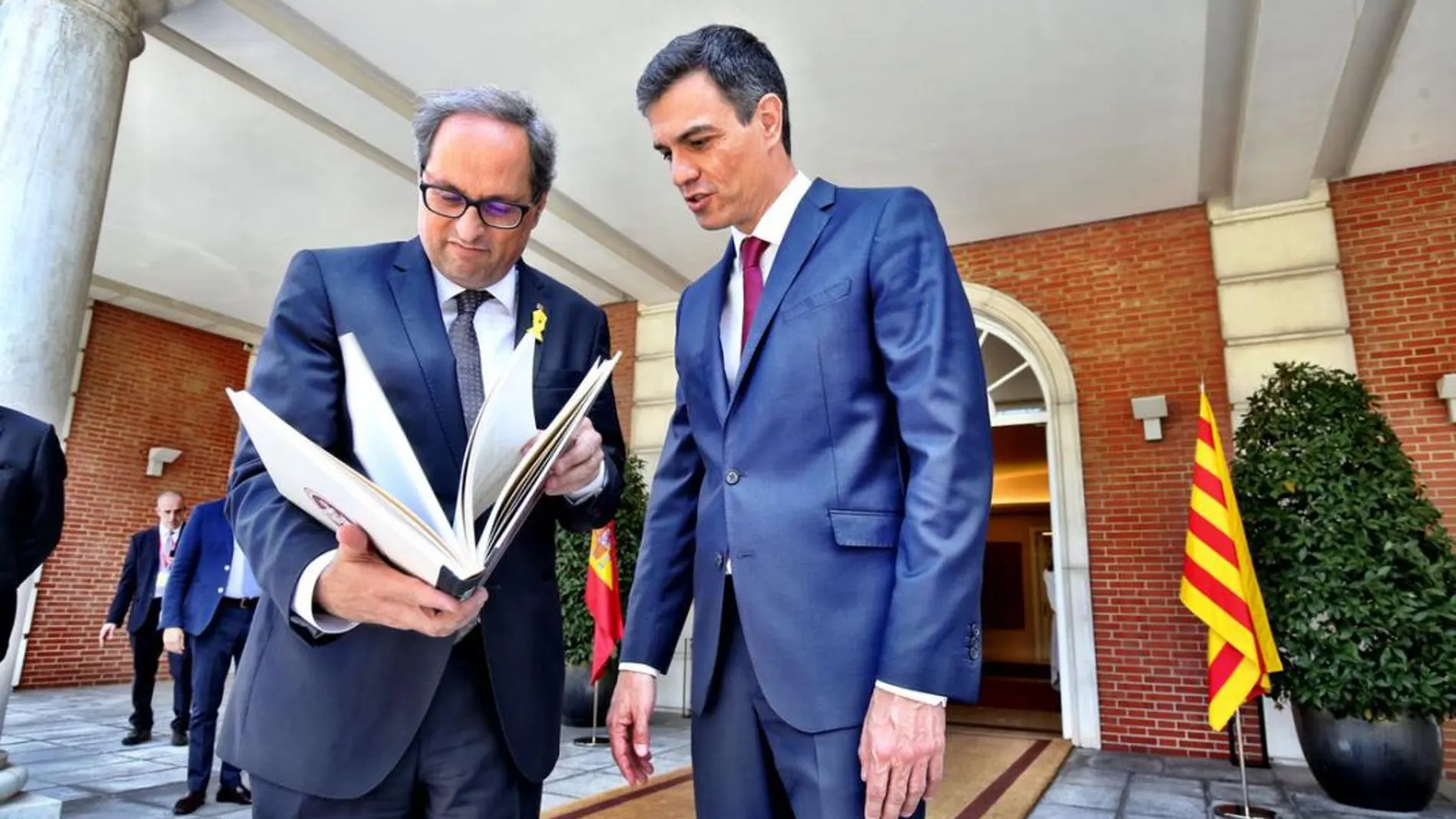 Torra y Sánchez miran un libro sobre el Palacio de la Moncloa tras la reunión que ambos han mantenido este mañana en Madrid. (Twitter)