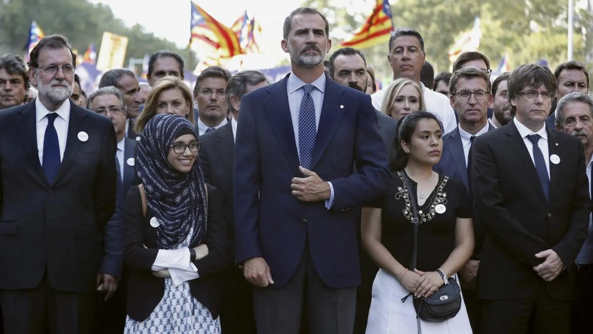 El rey Felipe VI, junto a los presidentes del Gobierno, Mariano Rajoy (i); de la Generalitat, Carles Puigdemont (d), en la cabecera de la manifestación contra los atentados yihadistas en Cataluña