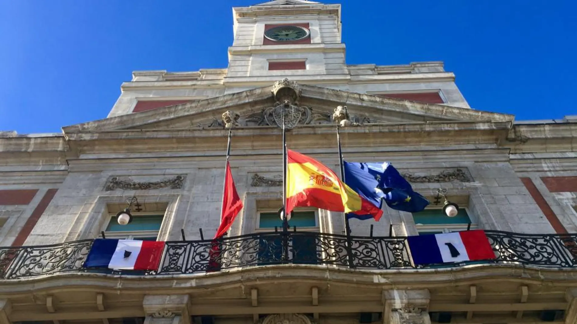 Dos banderas francesas con crespón negro presiden la sede de la Comunidad de Madrid