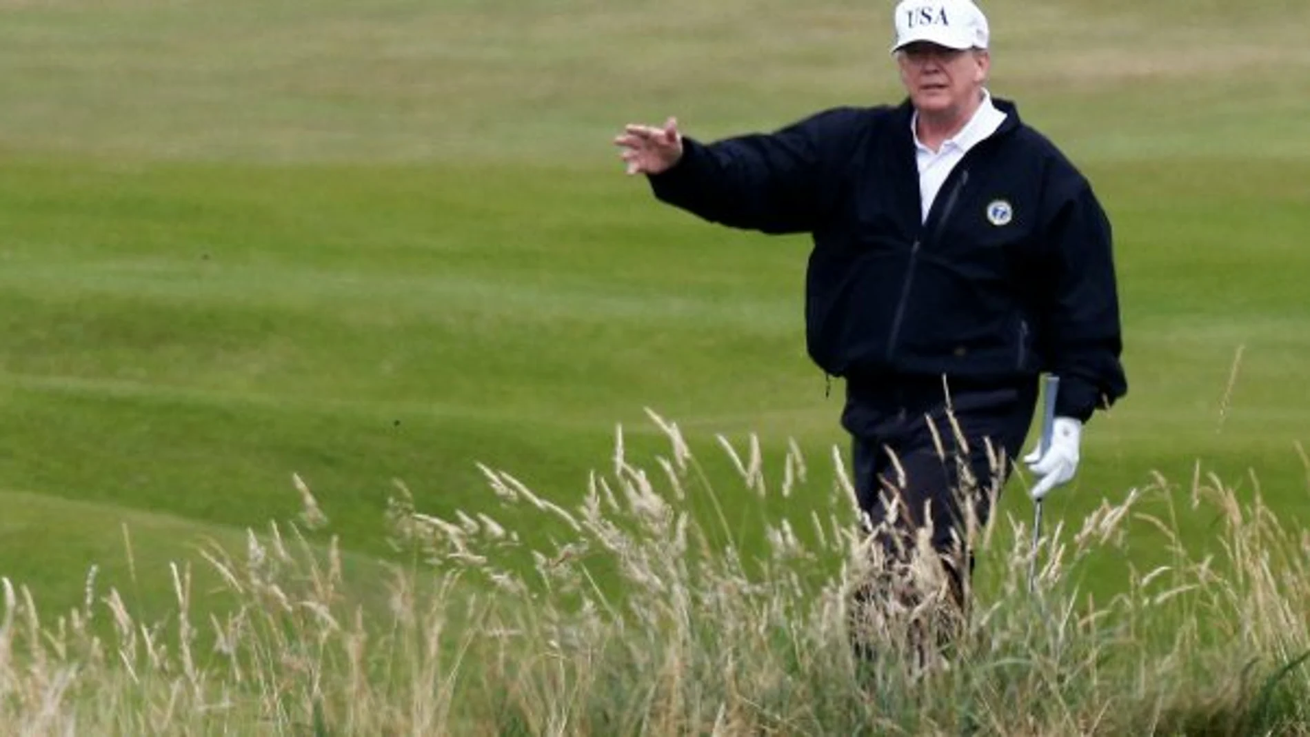 Donald Trump hace un gesto mientras camina en su campo de golf, en Turnberry (Escocia) / Reuters