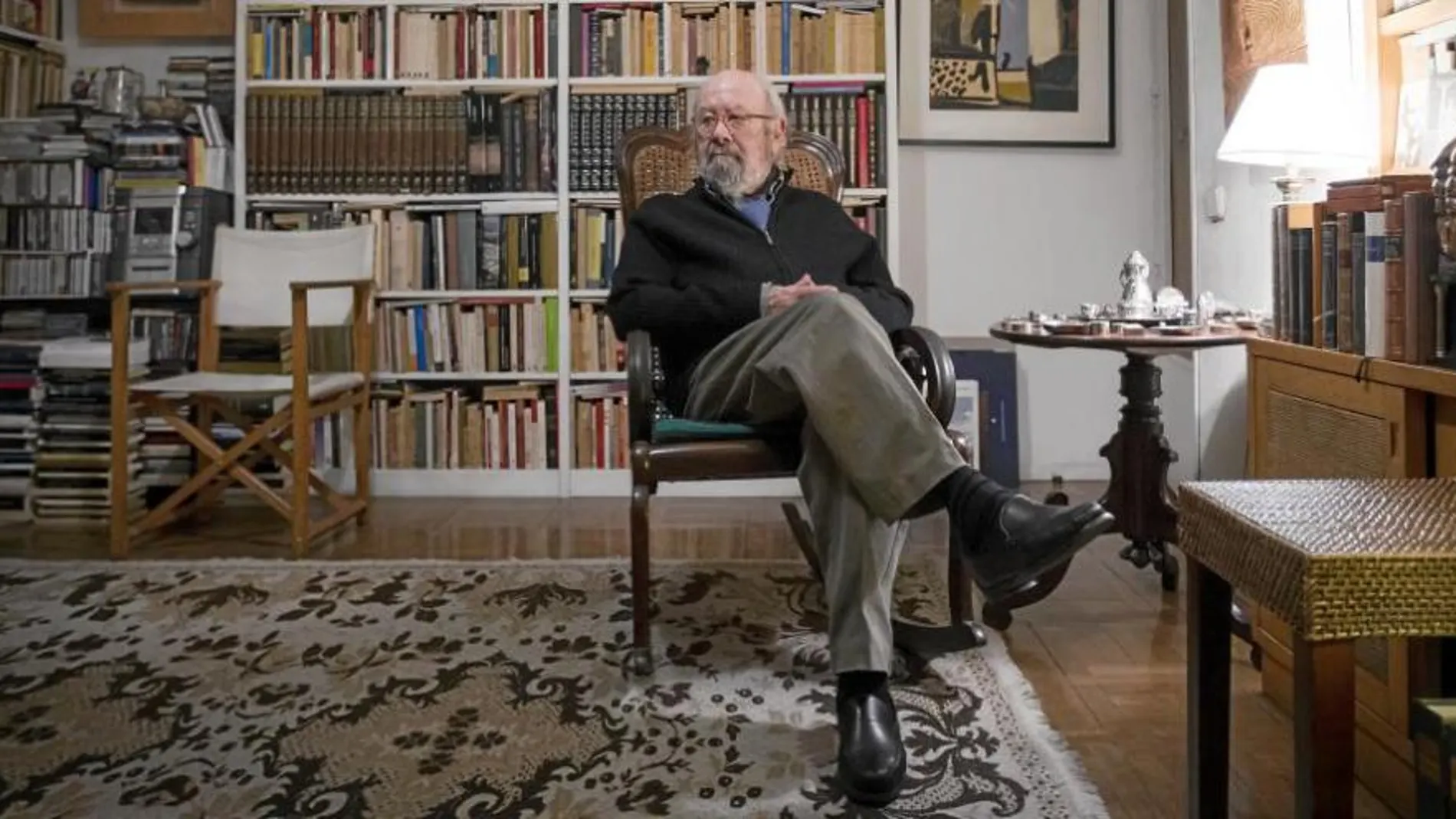 El escritor, ayer, en su casa de Madrid, posa delante de su biblioteca, salpicada de recuerdos