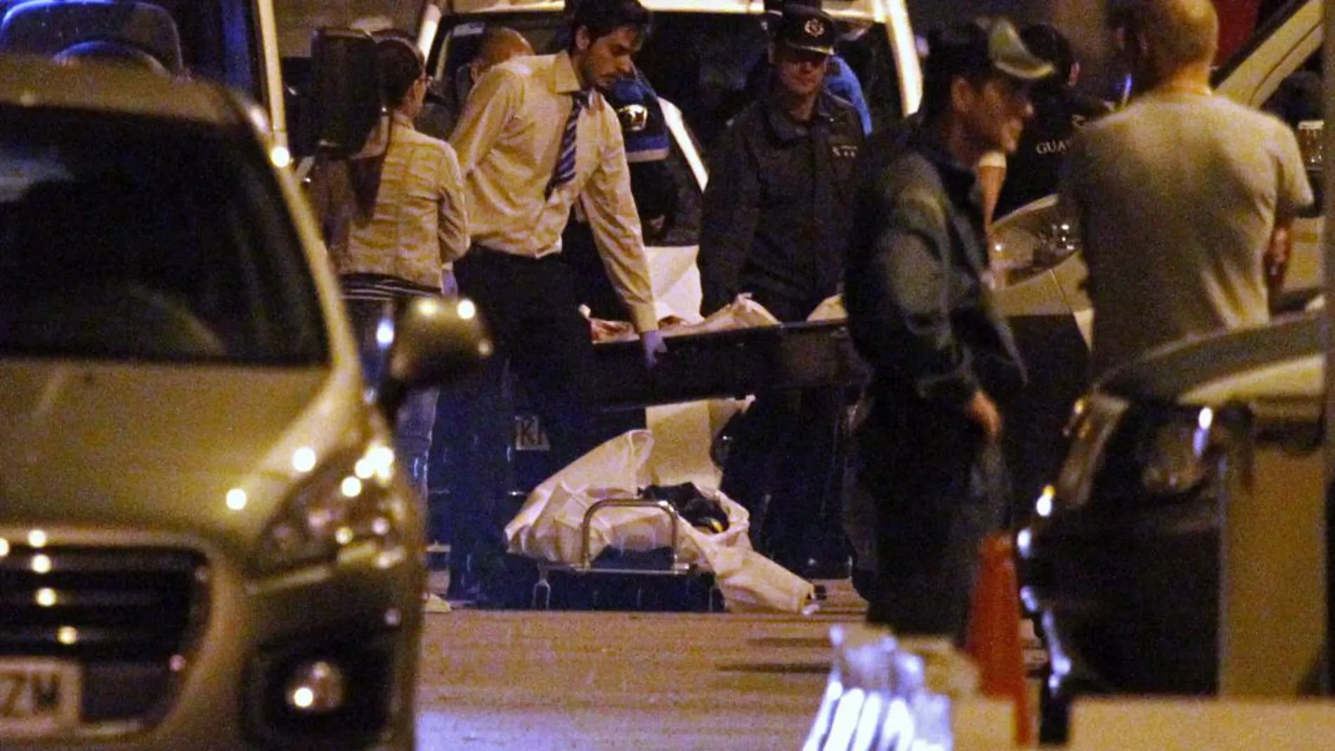 Agentes de la Guardia Civil y de los servicios funerarios junto a los cuerpos de dos de las cuatro personas que han fallecido hoy en aguas del Estrecho de Gibraltar