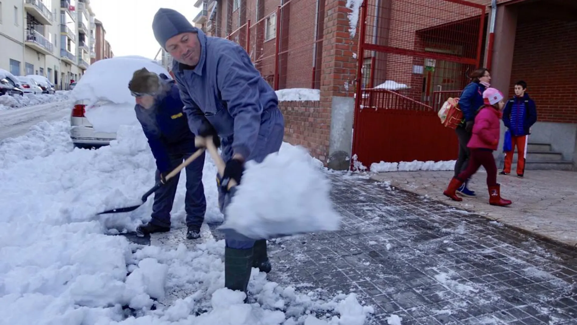 Un grupo de operarios liberan de nieve los accesos a un colegio en Ávila