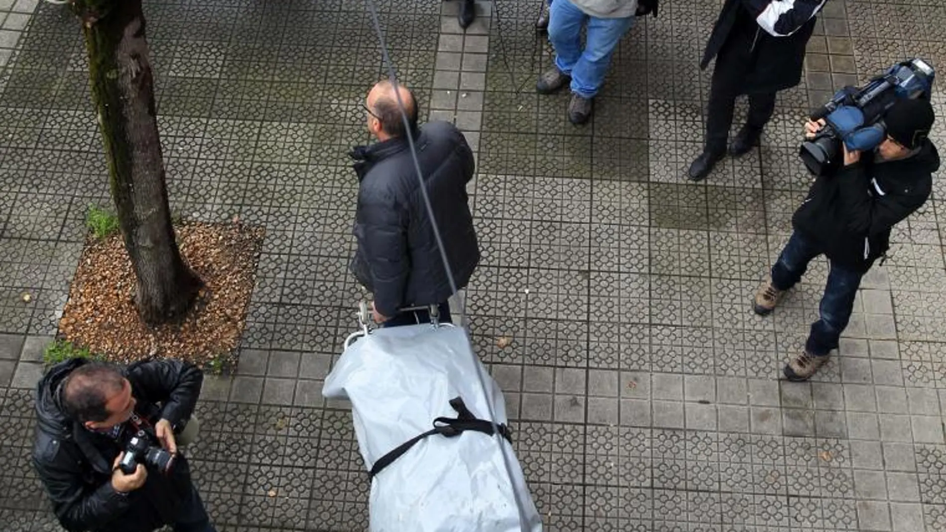 Trabajadores de servicios funerarios trasladan el cuerpo de una de las dos víctimas