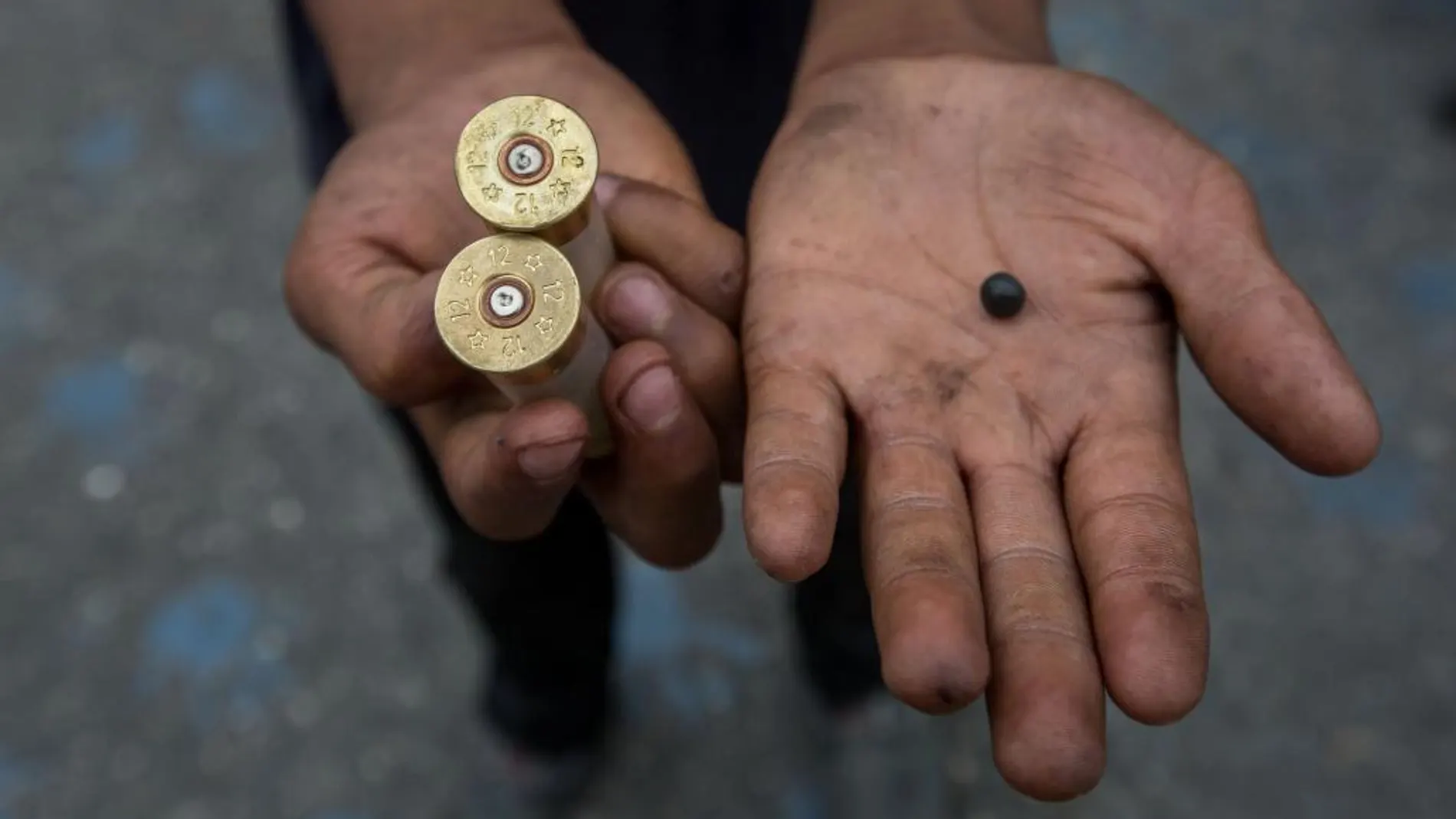 Un manifestante muestra un par de cartuchos de armas de fuego durante manifestación en contra del Gobierno venezolano.