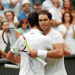 Nadal y Djokovic se abrazan después del partidazo que jugaron en las semifinales de Wimbledon / Reuters