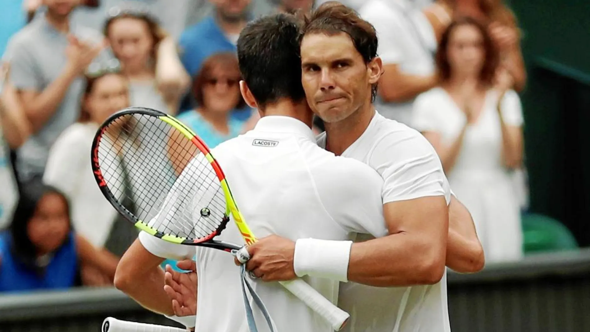 Nadal y Djokovic se abrazan después del partidazo que jugaron en las semifinales de Wimbledon / Reuters