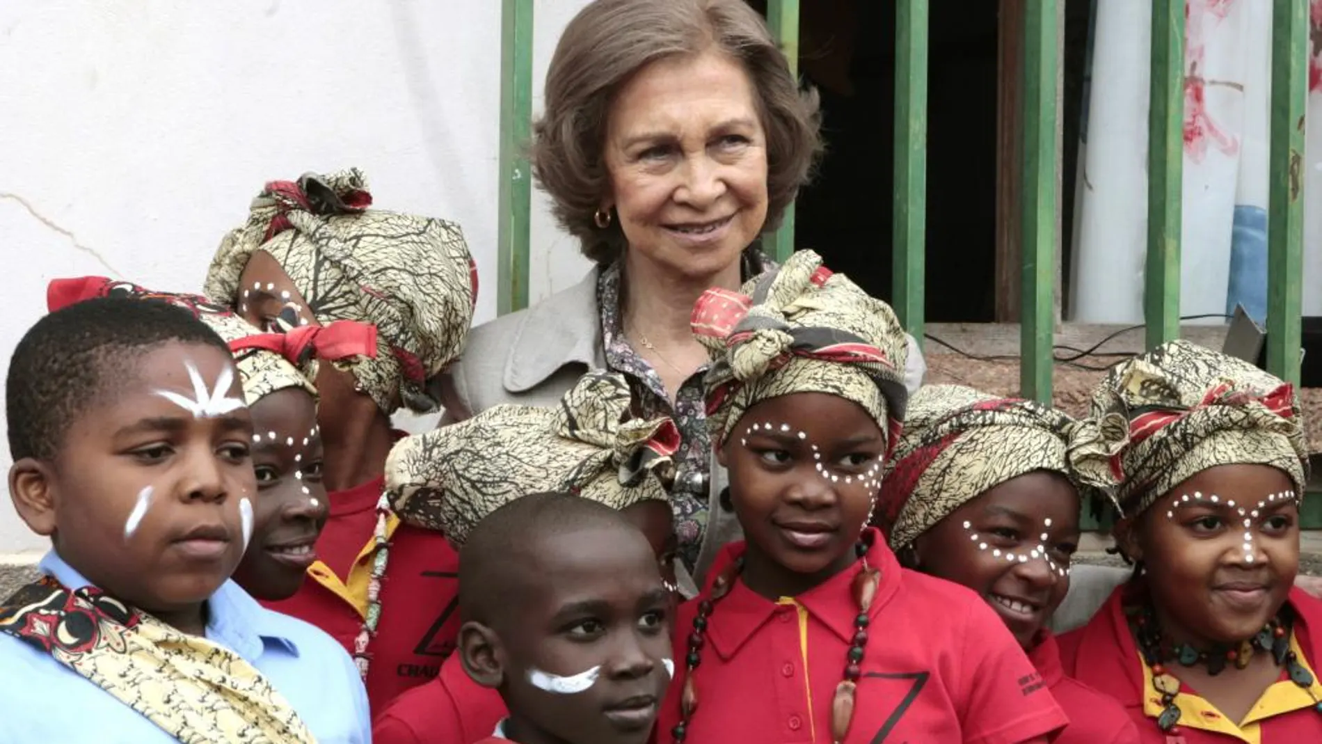 La Reina posa con unos niños de la Casa do Gaiato durante la visita que ha realizado hoy a este centro infantil para huérfanos en el municipio de Namaacha.