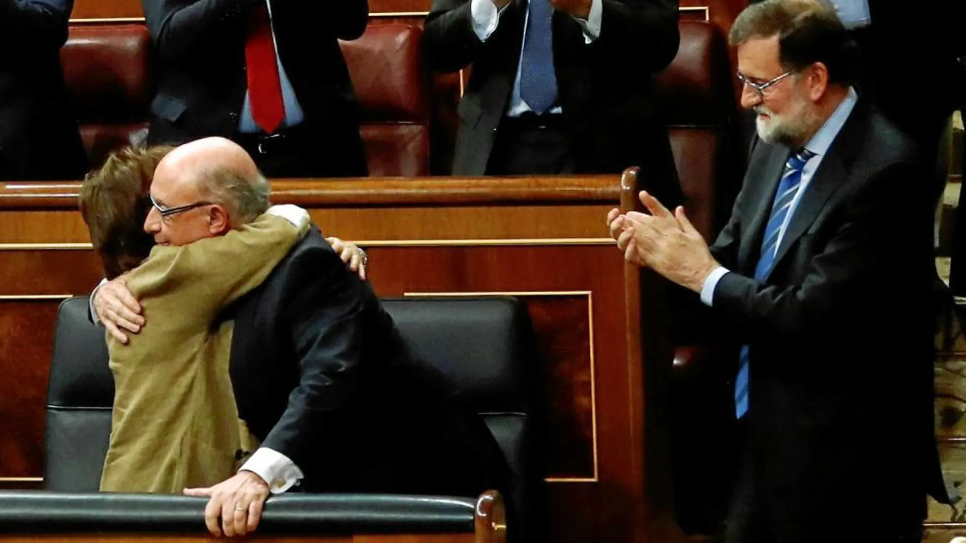 Rajoy aplaude a Montoro tras la aprobación de los Presupuestos ayer en el Congreso