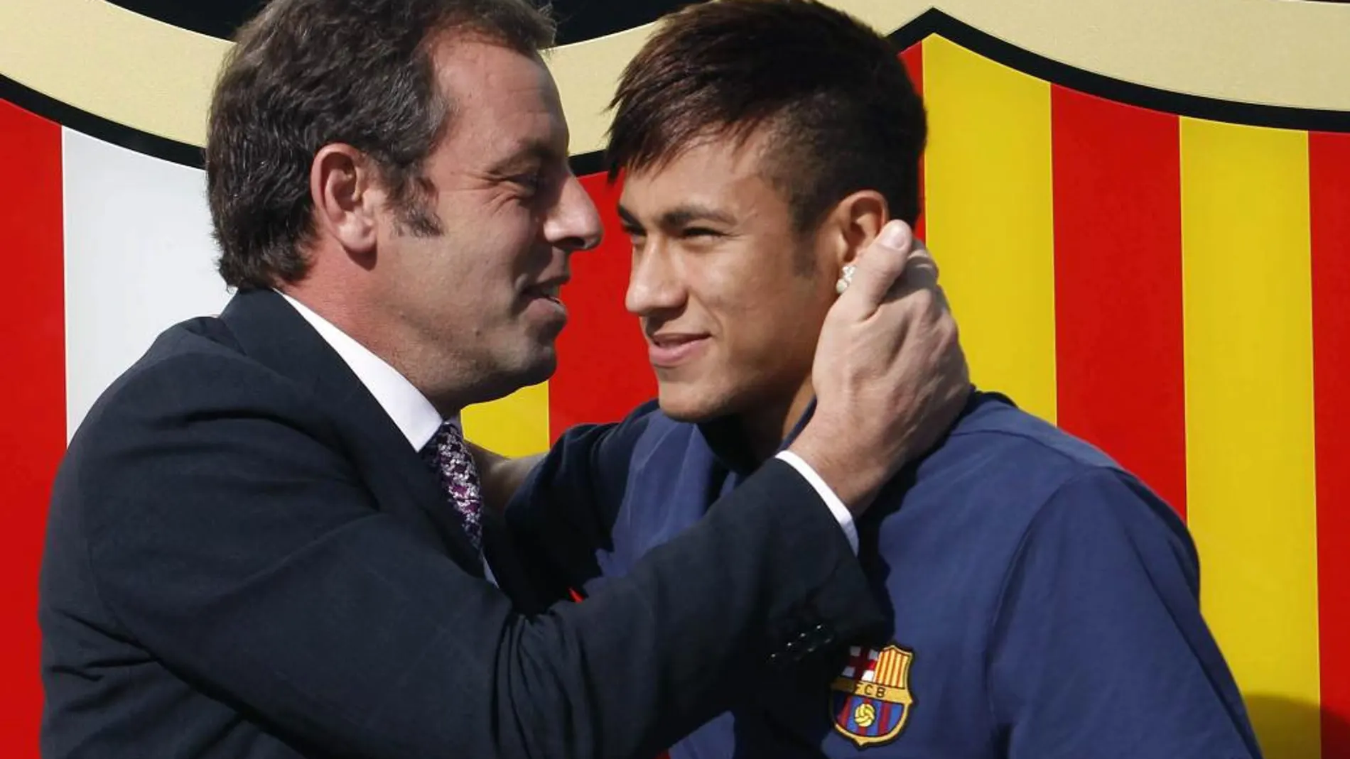 El jugador brasileño del FC Barcelona, Neymar da Silva (d) junto a Sandro Rosell durante su presentación en Barcelona.