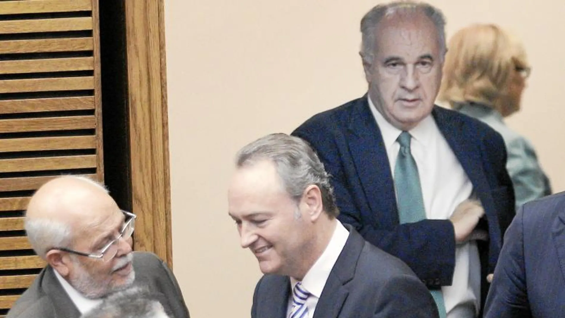 El presidente Fabra habla con varios diputados a la entrada del hemiciclo. Atrás, el exconseller Rafael Blasco