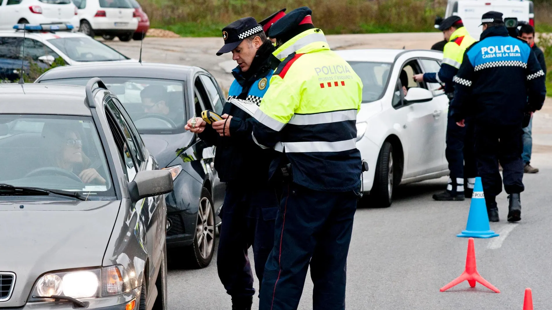 Miembros de los Mossos d'Esquadra y de la policia local de Cassà de la Selva (Girona) realizan un control de alcohol en la carretera C-65 que forma parte de campaña de controles de alcohol y drogas / EFE