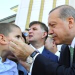 El presidente turco, Tayyip Erdogan, coge la cara de un niño en un acto celebrado ayer