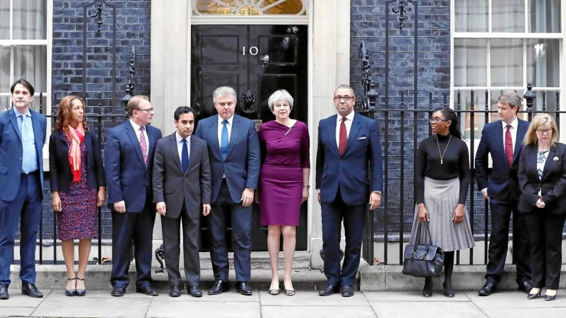 Theresa May posa con el nuevo presidente del Partido Conservador, Brandon Lewis (a su dcha.) y el vicepresidente, James Cleverly (izda.), junto a sus equipos a las puertas de Downing Street