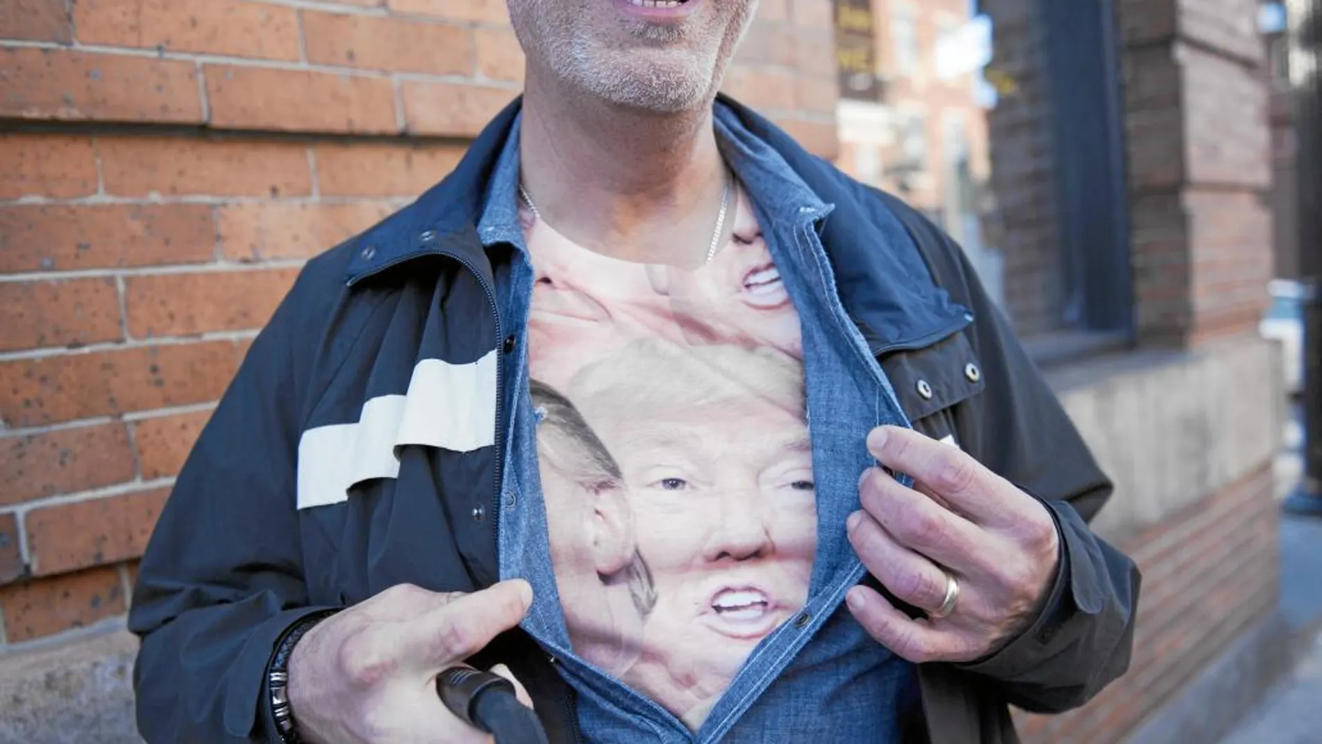 Un seguidores de Donald Trump muestra una camiseta con el rostro del candidato republicano