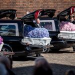 Los féretros blancos de los tres niños cubiertos de flores