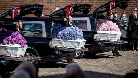 Los féretros blancos de los tres niños cubiertos de flores