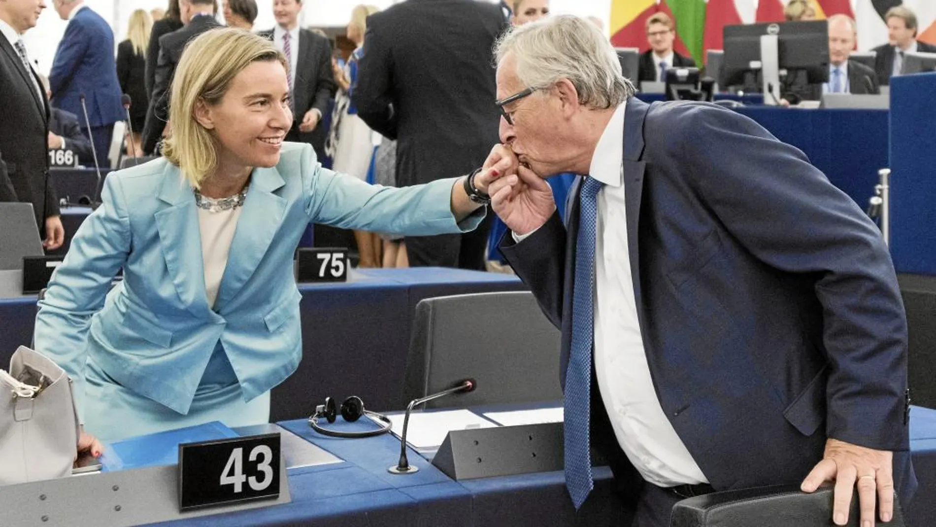 El presidente de la Comisión Europea, Jean-Claude Juncker, besa la mano de la jefa de la diplomacia europea, Federica Mogherini