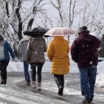 Varias personas caminan por una carretera de la localidad lucense de O Cebreiro.