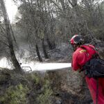 Un miembro de la UME refresca zonas quemadas en el perímetro del incendio de la Sierra de Espadán