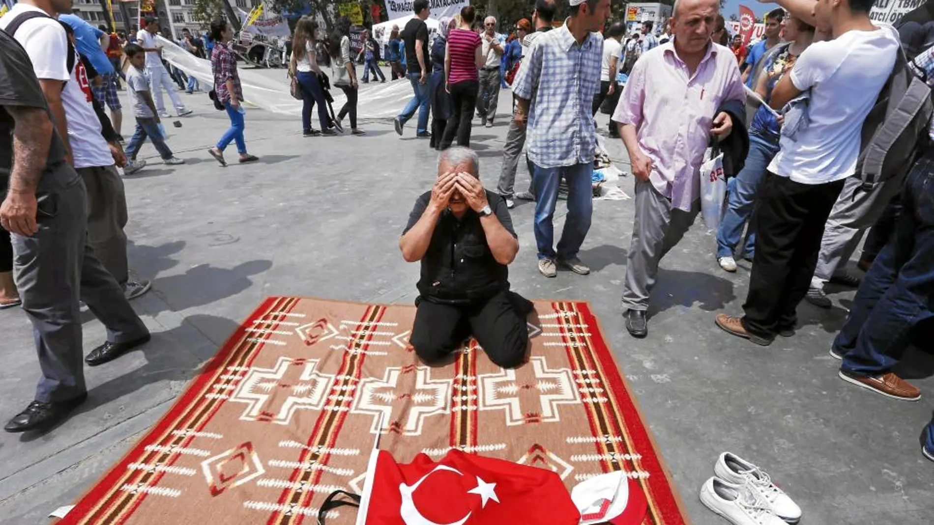 Hassan, un pensionista de 67 años, reza en medio de las protestas en contra del Gobierno en la plaza Taksim, en Estambul, ayer