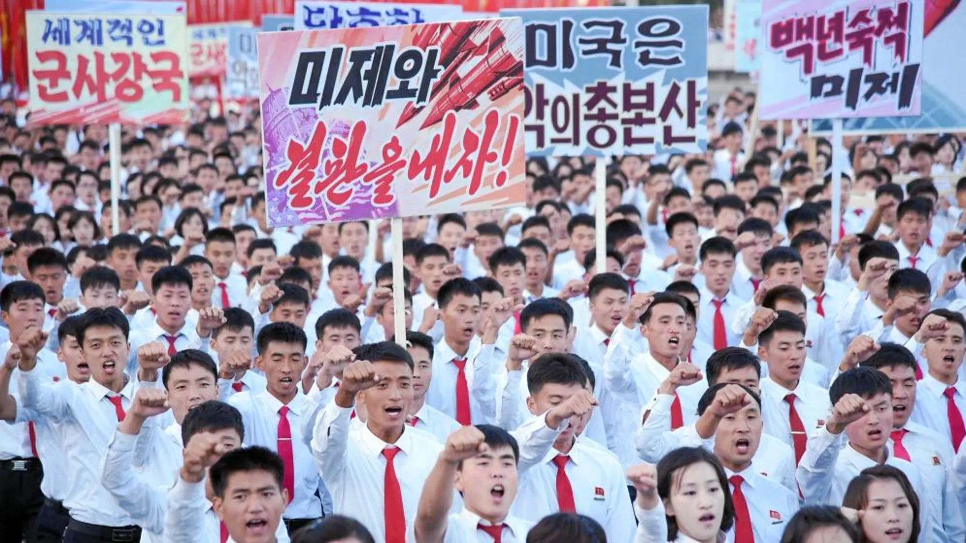 Varios jóvenes alineados del régimen norcoreano claman contra Estados Unidos en una concentración en el centro de Poyongyang