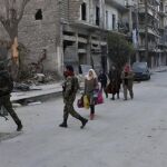 Varias personas evacúan los barrios del este de Alepo.