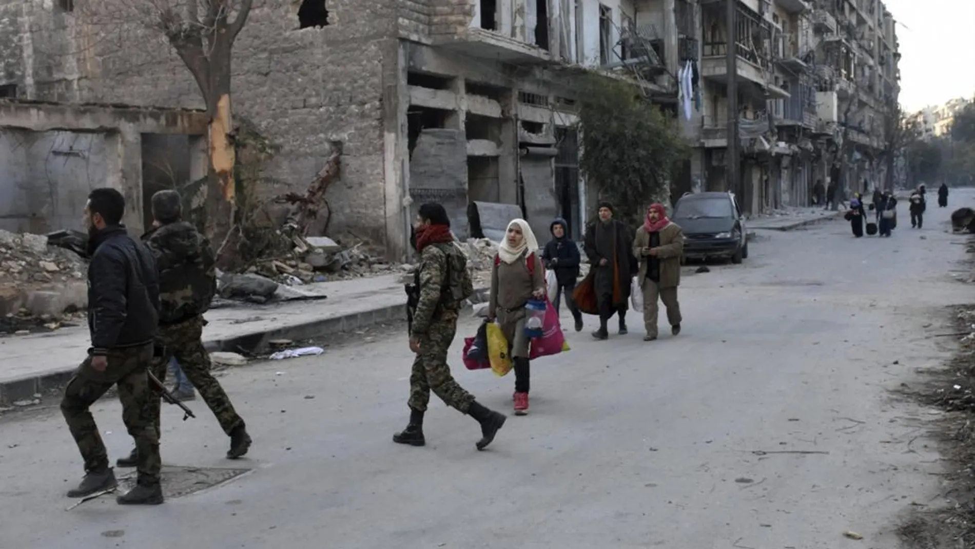Varias personas evacúan los barrios del este de Alepo.