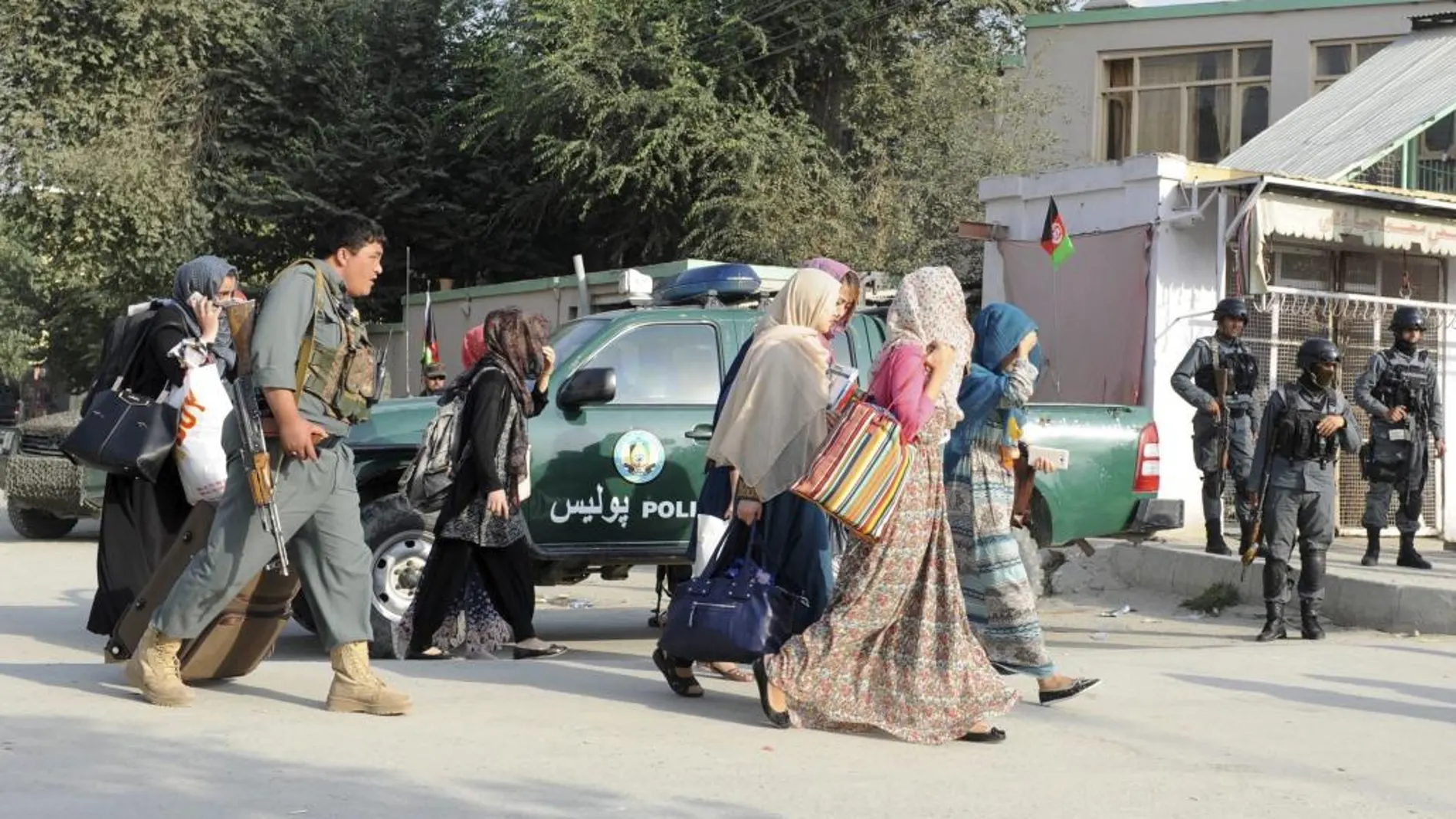 Estudiantes de la Universidad Americana son escoltados por las fuerzas de seguridad mientras abandonan las instalaciones en Kabul.