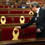 El presidente de la Generalitat, Quim Torra, coloca un lazo amarillo en el Parlament. Foto: Efe