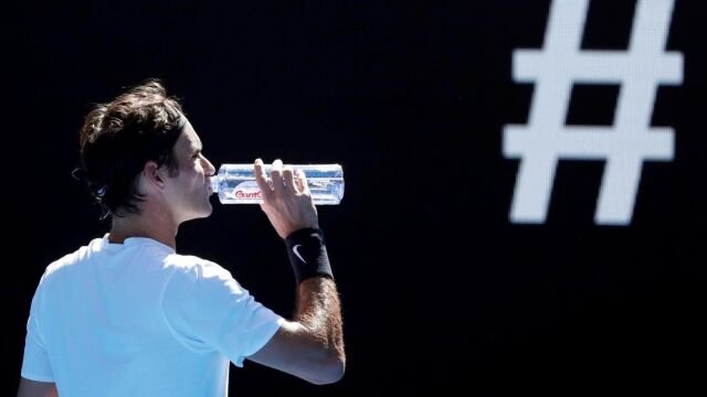 El suizo Rogerd Federer bebe agua durante un descanso en su partido de la cuarta ronda del Abierto de Australia contra el húngaro Marton Fucsovics.